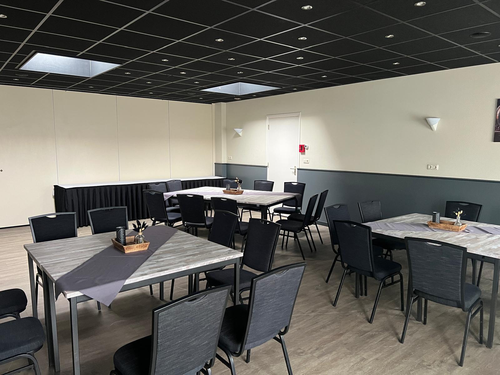 Zaal Oost in Dorpshuis Hierden, ingericht met tafels voor een vergadering.