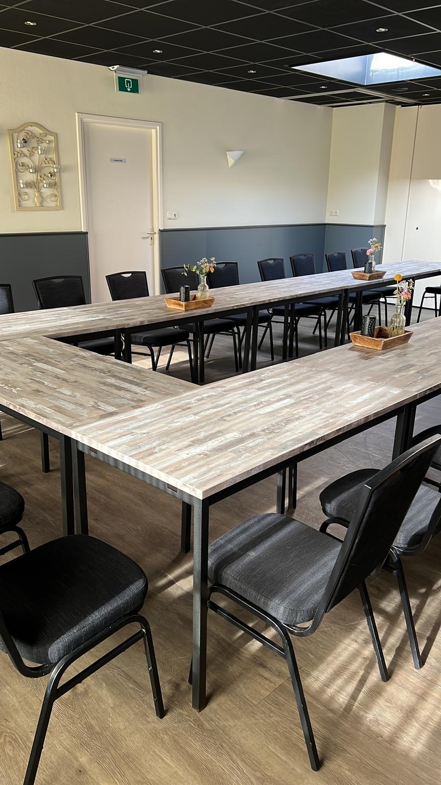 De grote zaal van Dorpshuis Hierden met statafels, klaar voor een receptie.